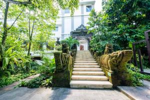 吉安雅Taman Prakerti Bhuana Hotel的花园内的楼梯,建筑背景