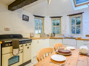 a kitchen with a table and a stove and a table and chairs at 3 Bed in Lynton 78823 in Lynmouth