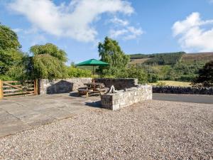 a stone patio with a table and an umbrella at 3 bed property in Blair Atholl 78841 in Trinafour