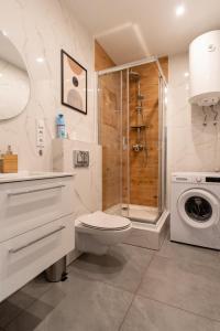y baño con ducha, aseo y lavadora. en Apartament Naturalny - blisko centrum by SpaceApart, en Jelenia Góra
