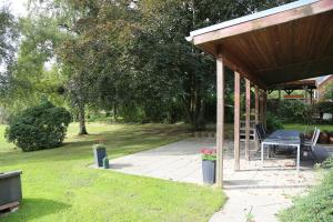 - un pavillon avec une table de pique-nique et un banc dans l'établissement Monteurzimmer an der Schlei, à Rabenkirchen-Faulück