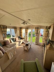 a living room with couches and a table at Bayview Bliss - Holiday Caravan in Newbiggin by the Sea - Northumberland in Newbiggin-by-the-Sea