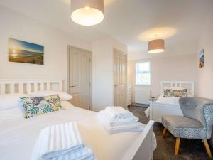 1 dormitorio con 2 camas, silla y escritorio en 4 bed in Nr Druridge Bay 79370, en Hadston