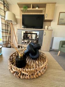 a living room with a table with a wicker basket at Bayview Bliss - Holiday Caravan in Newbiggin by the Sea - Northumberland in Newbiggin-by-the-Sea