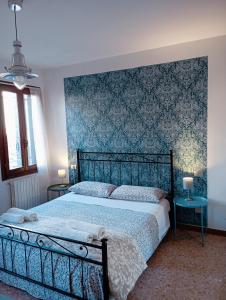 um quarto com uma cama grande e uma parede azul em Two Steps from Rialto em Veneza