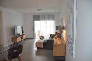 een woonkamer met een bank en een tv bij Great apartment penthouse 2 bedrooms Tejita Beach in El Médano
