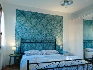 um quarto com uma cama com uma parede azul em Two Steps from Rialto em Veneza