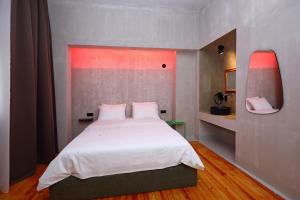 a bedroom with a large bed with white sheets at Paradox in Thessaloniki