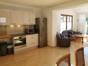 a kitchen with stainless steel appliances and a living room at Ferienwohnung Filser in Prien am Chiemsee