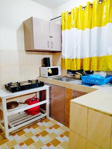 a small kitchen with a sink and a stove at Cozy Haven Slumber in Nanyuki