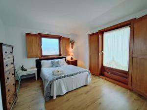 梅爾加蘇的住宿－Casa da Telhada Pequena，一间卧室设有一张床和两个窗户。