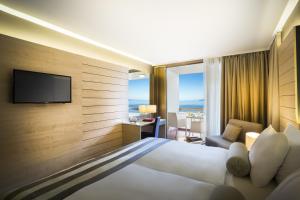 une chambre d'hôtel avec un lit et une télévision dans l'établissement Hotel Excelsior - Liburnia, à Lovran
