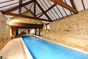 a large swimming pool in a building with a brick wall at Finest Retreats - The Park in Onibury