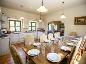 a dining room with a long table and chairs at Finest Retreats - The Park in Onibury