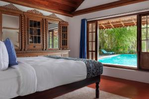 a bedroom with a bed and a swimming pool at BluSalzz Escapade - Muhamma, Alleppey - Kerala in Alleppey