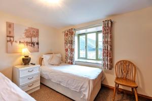 sypialnia z łóżkiem, oknem i krzesłem w obiekcie Finest Retreats - Norton Cottage w mieście Onibury