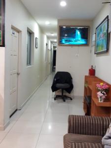 einen Krankenhausflur mit einem Stuhl und einem TV an der Wand in der Unterkunft Camlodge Budget Hotel in Cameron Highlands