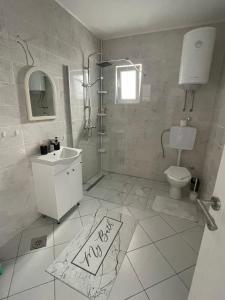 uma casa de banho branca com um lavatório e um WC em Apartman DB em Višegrad