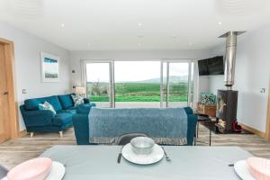 a living room with a blue couch and a table at High Tide Lodge in Gatehouse of Fleet