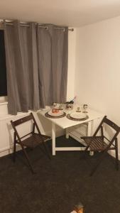Welcome to Tring Cymric Home في ترينج: طاولة بيضاء و كرسيين في الغرفة
