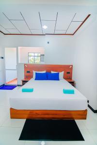 - une chambre avec un grand lit et des oreillers bleus dans l'établissement Apartments by Tyzon, à Aluthgama