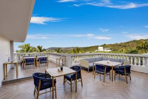 a patio with tables and chairs on a balcony at Antarim Resort in Candolim