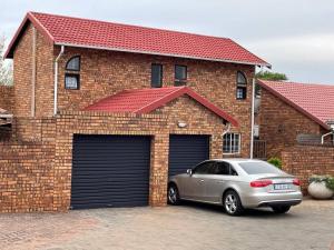 a car parked in front of a brick house at Magalies House in Pretoria