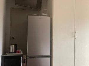 a white refrigerator in a kitchen next to a microwave at Magalies House in Pretoria