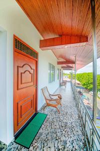 Cette chambre dispose d'une porte en bois et de bancs sur une terrasse couverte. dans l'établissement Apartments by Tyzon, à Aluthgama