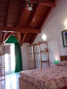 a bedroom with a bed and some wooden ceilings at Hostels Holiday Cape Verde in Santa Maria
