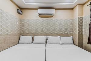 a room with two beds and a air conditioner at OYO Flagship Sree Vishnu Bhavan in Tirupati