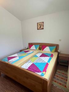 a bedroom with a wooden bed with colorful blankets at Apartment Liznjan 3 in Ližnjan