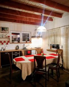 een keuken met een tafel met een rode en witte tafeldoek bij Ranczo Ignacowo in Studzienno