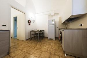 eine Küche mit einem Tisch und einem Kühlschrank in der Unterkunft Casa Vacanza La Fornace Matera centro in Matera