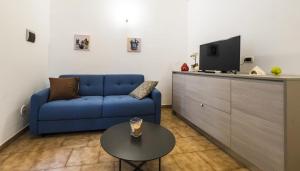 ein Wohnzimmer mit einem blauen Sofa und einem Tisch in der Unterkunft Casa Vacanza La Fornace Matera centro in Matera