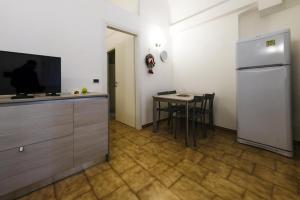 una cucina con un tavolino e un frigorifero di Casa Vacanza La Fornace Matera centro a Matera Altre 7 foto