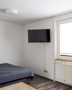 ein Schlafzimmer mit einem Bett und einem Flachbildfernseher an der Wand in der Unterkunft Exclusive Home Feeling Flat in Ratingen