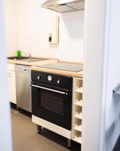 eine Küche mit einem schwarzen Herd und einer Spüle in der Unterkunft Exclusive Home Feeling Flat in Ratingen