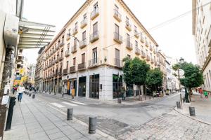 an empty city street with a large building at Piso junto a Mercado de San Agustín y Catedral en Granada in Granada