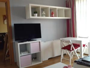 salon z telewizorem i stołem z krzesłem w obiekcie Apartamento Calle Mauricio Legendre w Madrycie