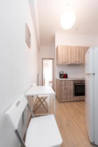 a kitchen with a white refrigerator and a table at Urban Studio in Koukaki steps to Acropolis in Athens