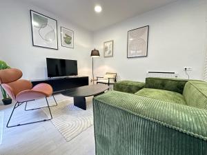 uma sala de estar com um sofá verde e uma mesa em Elegante hogar en el centro em Vigo