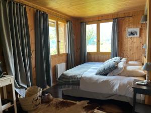 ein Schlafzimmer mit einem Bett in einem Zimmer mit einem Fenster in der Unterkunft Chalet l'Aigle bleu in Uvernet