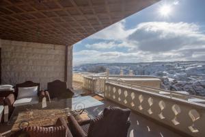 balcón con sillas y vistas a la ciudad en Cappadocia Fairy Chimneys Minia Cave Hotel, en Ortahisar