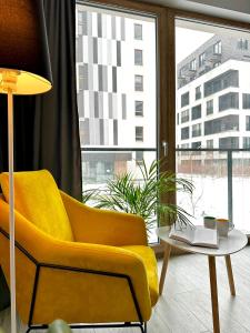 Sala de estar con silla amarilla y mesa en Apartment Mokotów blisko lotniska Chopina, en Varsovia