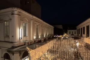 Una fila de edificios con luces de Navidad por la noche en The Baroness en Kalamata