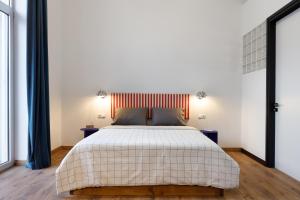 a bedroom with a large white bed with two tables at The Baroness in Kalamata