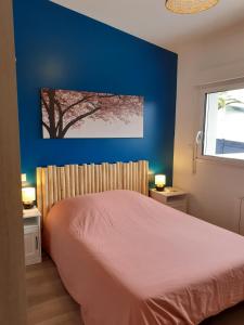 - une chambre avec un lit et un mur bleu dans l'établissement LENIE appartement reposant, à Lanester