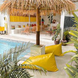 a pool with yellow pillows and a straw umbrella at Thandara kohlarn in Ko Larn