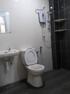 een badkamer met een douche, een toilet en een wastafel bij Camlodge Apartments in Tanah Rata